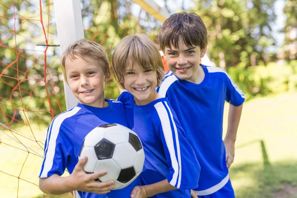 Tres, muchacho joven con pelota de fútbol en un uniforme deportivo — Foto de Stock