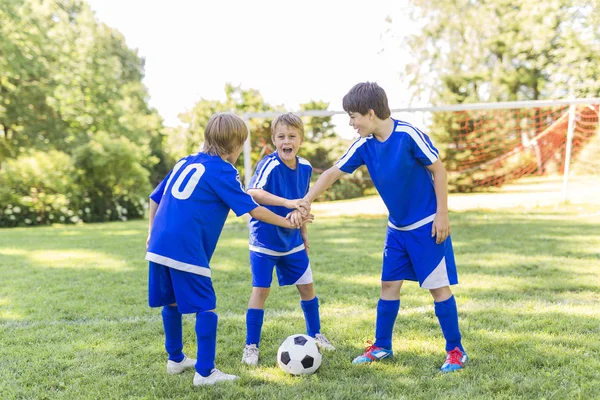 Drie, jongen met voetbal op een sport uniforme — Stockfoto