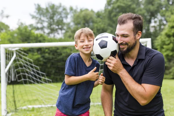 Vader en zoon voetballen op het voetbalveld — Stockfoto