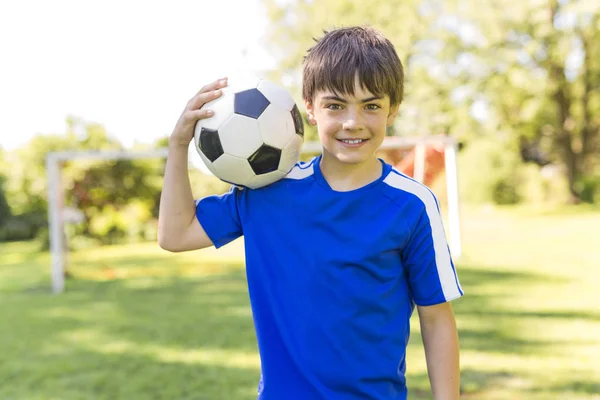 スポーツのユニフォームにはサッカー ボールの少年 — ストック写真