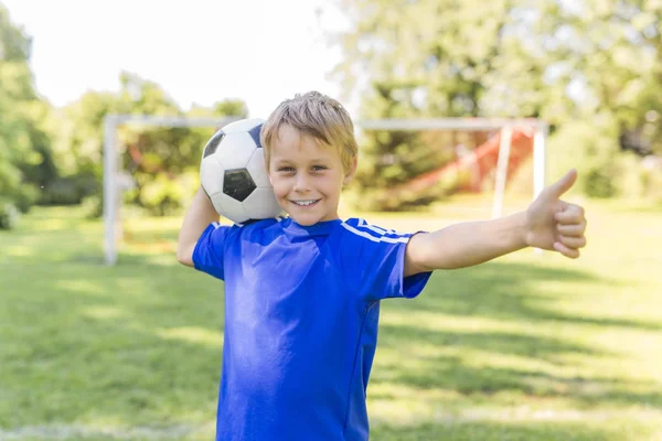スポーツのユニフォームにはサッカー ボールの少年 — ストック写真