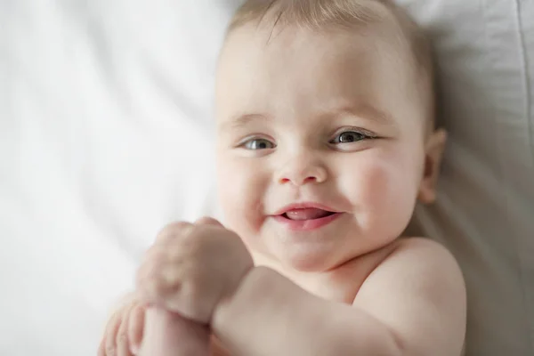 Linda niña feliz de 7 meses en pañal mintiendo y jugando — Foto de Stock