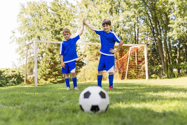 Dos jovencito con pelota de fútbol en un uniforme deportivo — Foto de Stock