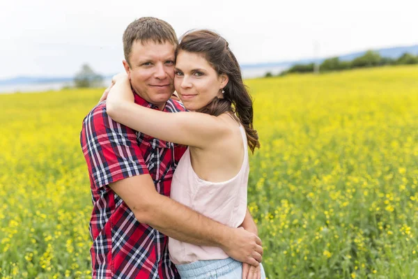 Feliz sonrisa joven pareja sobre amarillo verde violación prado — Foto de Stock