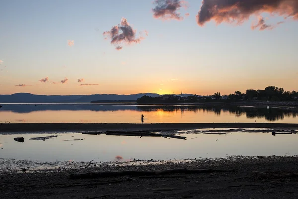 Pôr do sol na Gaspesie Canadá com pescador retroiluminado — Fotografia de Stock