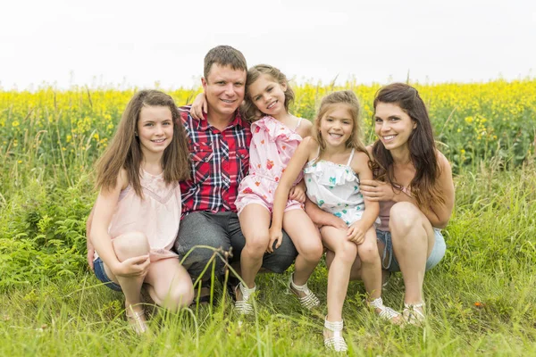 Family outdoors on a yellow field — Stock Photo, Image