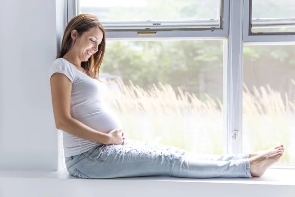 Donna incinta con la pancia su sfondo bianco — Foto Stock