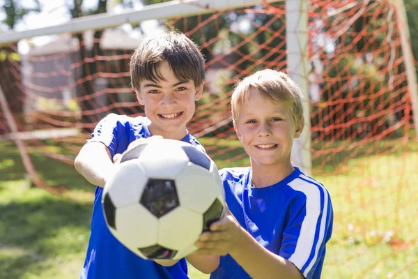 Två ung pojke med fotboll på idrotten uniform — Stockfoto