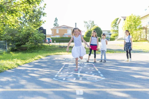 Glada skolåldern barn spela på lekplats skola — Stockfoto