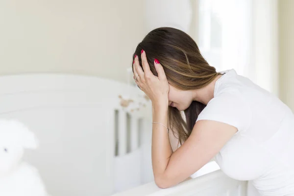 Depressed young woman in baby room — Stock Photo, Image