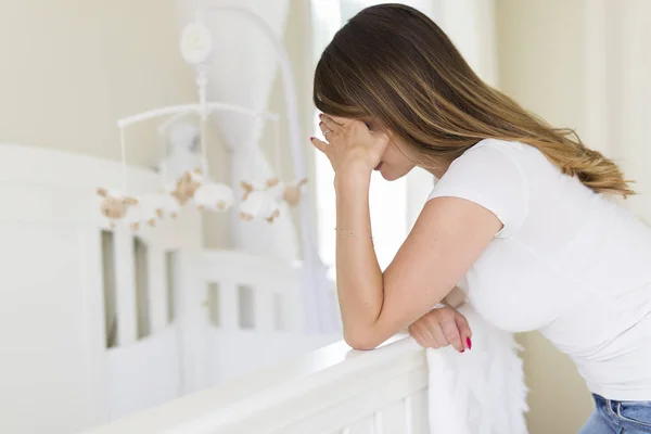 赤ちゃんの部屋で落ち込んでいる若い女性 — ストック写真