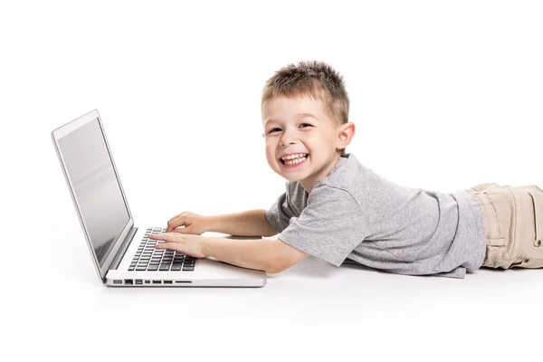 Little kid with laptop lay on the ground — Stock Photo, Image