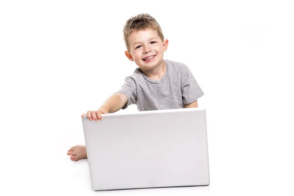 Little kid with laptop lay on the ground — Stock Photo, Image