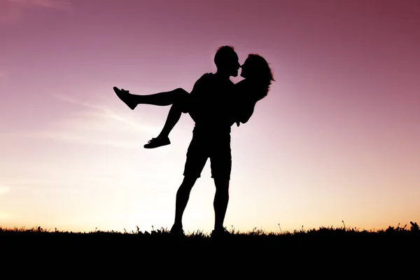 Silueta de amantes románticos con puesta de sol en la espalda — Foto de Stock