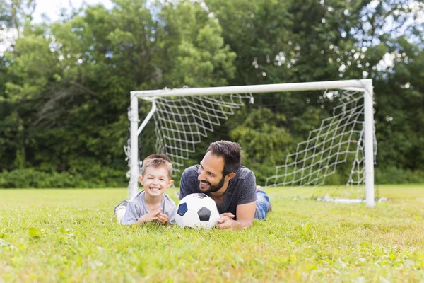 Jonge vader met zijn zoontje voetballen op voetbalveld — Stockfoto