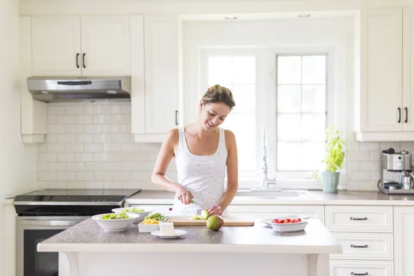 Magnifique femme faisant une salade dans sa cuisine — Photo