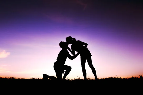 Silhouette d'amoureux romantiques avec coucher de soleil sur le dos — Photo
