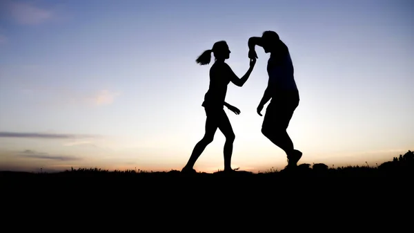 Silueta de una pareja bailando contra el cielo azul —  Fotos de Stock