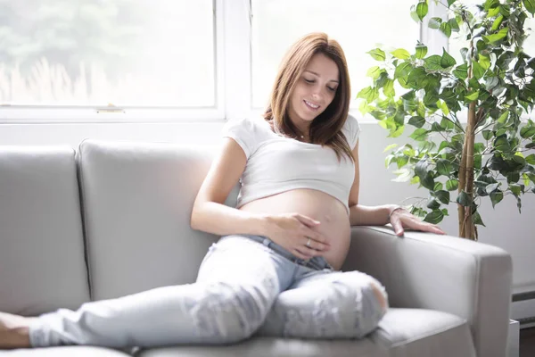 白い背景の上の彼女の腹の妊娠中の女性 — ストック写真