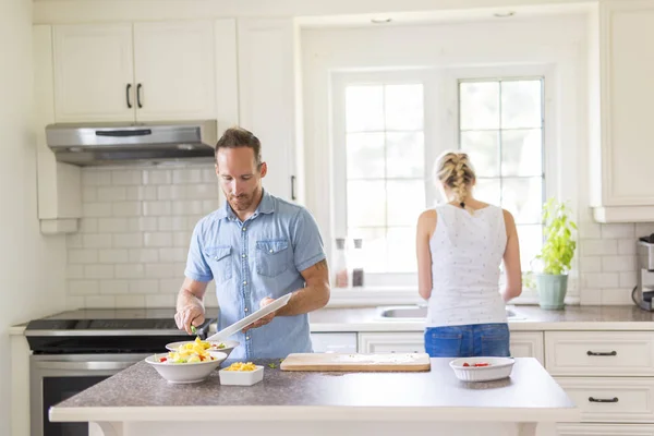 Couple dans la cuisine faire de la salade ensemble — Photo