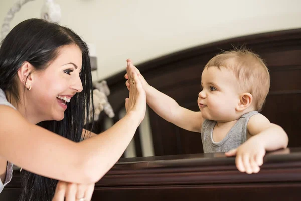 Mère endormir bébé au berceau — Photo