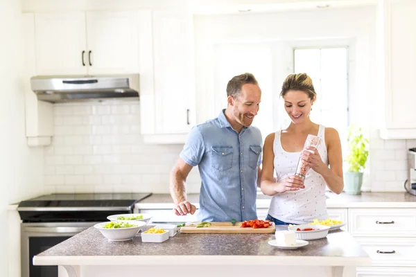 Coppia in cucina facendo insalata insieme — Foto Stock