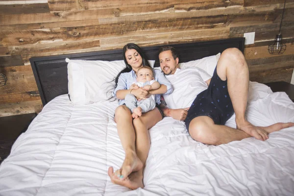 침대에 그들의 귀여운 작은 아이와 부모를 사랑 하 — 스톡 사진