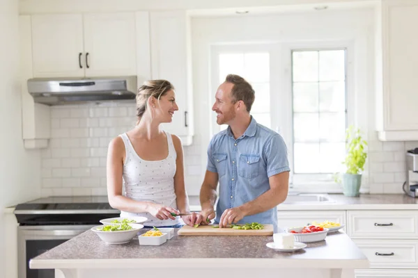 Couple dans la cuisine faire de la salade ensemble — Photo