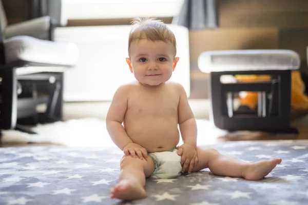 Glücklicher kleiner Junge sitzt zu Hause auf dem Boden — Stockfoto