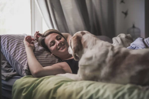 Frau mit Hund zu Hause im Bett — Stockfoto