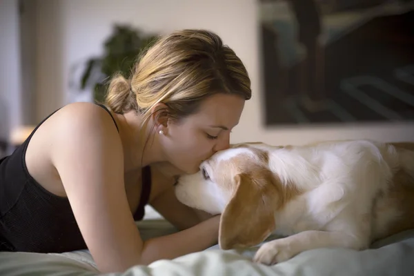Женщина со своей собакой в постели дома — стоковое фото