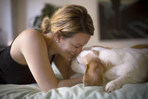 Frau mit Hund zu Hause im Bett — Stockfoto
