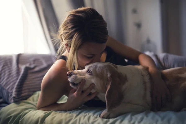 Frau mit Hund zu Hause im Bett — Stockfoto