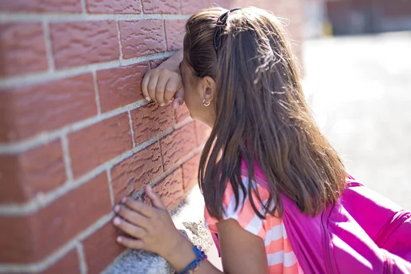 Niña de seis años de edad lloran junto a la pared de ladrillo —  Fotos de Stock