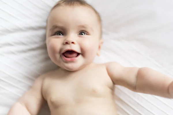 Linda niña feliz de 7 meses en pañal mintiendo y jugando — Foto de Stock