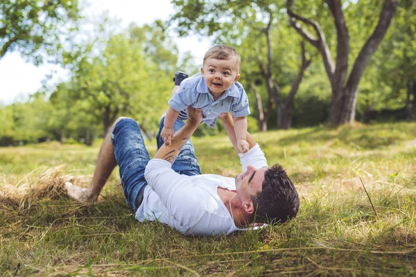 Schöner Vater kleiner Kleinkind Sohn auf der Wiese. — Stockfoto