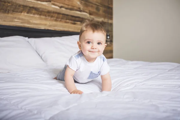 Niedlicher kleiner Junge in weißer Bettwäsche. — Stockfoto