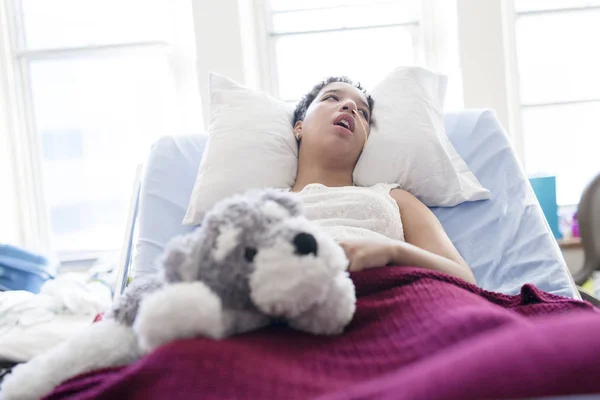 Sjuka patienten liggande på sängen i sjukhus för medicinska bakgrund — Stockfoto