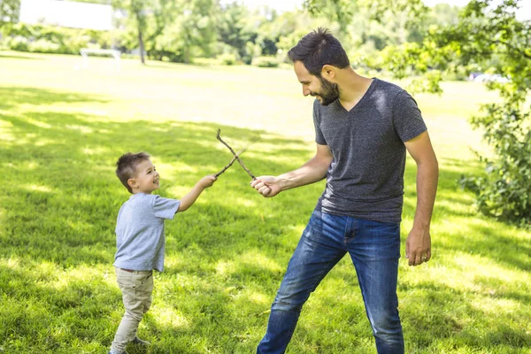 Vader en zoon spelen op de weide. — Stockfoto