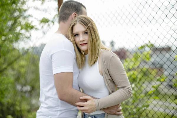 Couple close to a fence in a day — Stock Photo, Image