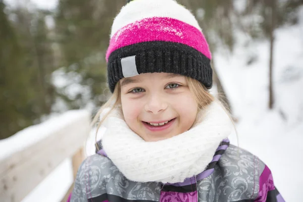 Niña en invierno sombrero rosa en el bosque de nieve . — Foto de Stock