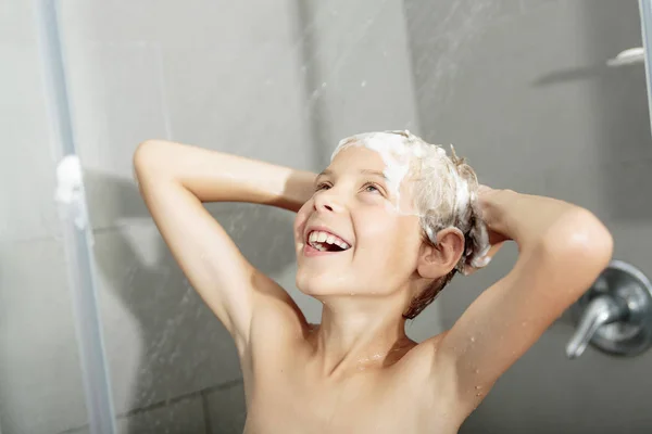 Щасливий підліток хлопчик миє голову в душі у ванній — стокове фото