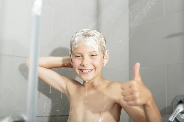 Gelukkig tiener jongen wassen hoofd in de douche in de badkamer — Stockfoto