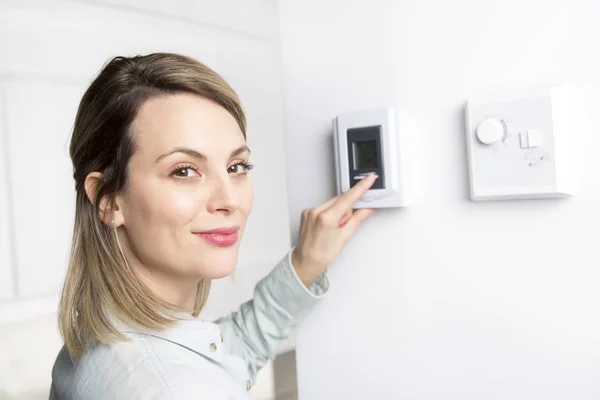 Mulher definir o termostato em casa . — Fotografia de Stock
