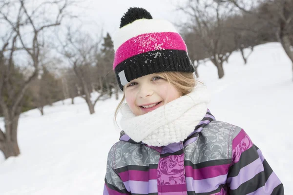 Niña en invierno sombrero rosa en el bosque de nieve . — Foto de Stock