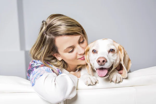 Schöne junge blonde Frau mit ihrem Hund zu Hause — Stockfoto