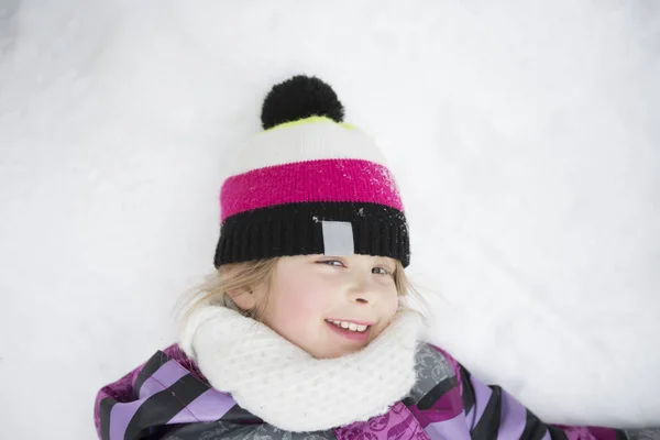 Маленькая девочка в зимней розовой шляпе в снежном лесу . — стоковое фото