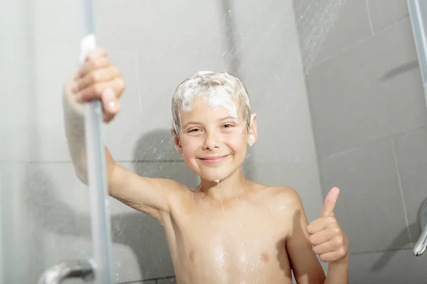 Gelukkig tiener jongen wassen hoofd in de douche in de badkamer — Stockfoto