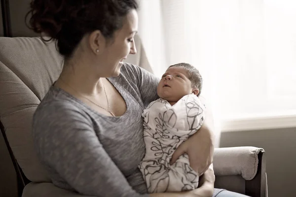 Boldog anya gazdaság imádnivaló gyermek baba a nappaliban — Stock Fotó