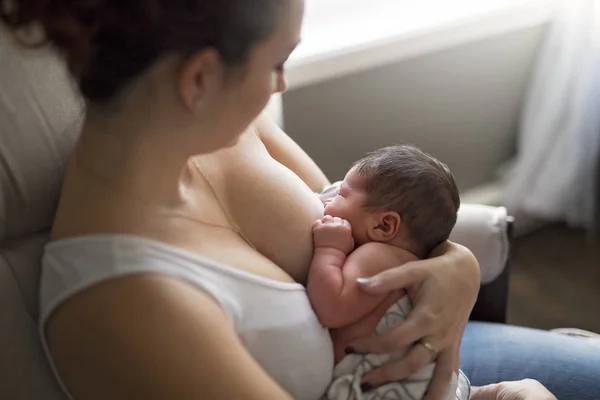 Mãe amamentando seu bebezinho nos braços . — Fotografia de Stock